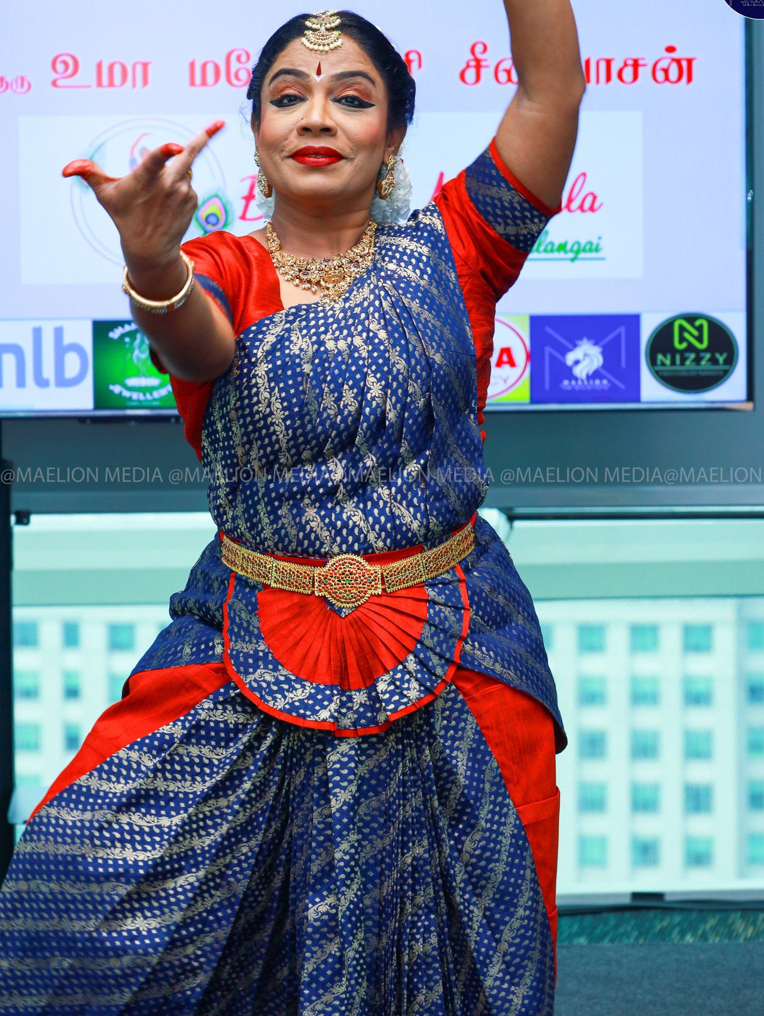 Guru Uma dancing with arms raised on stage