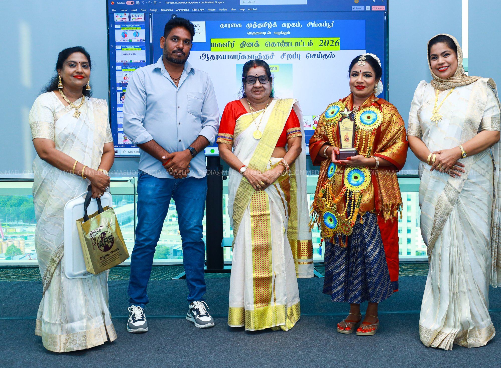 Guru Uma holding her award with the organisers