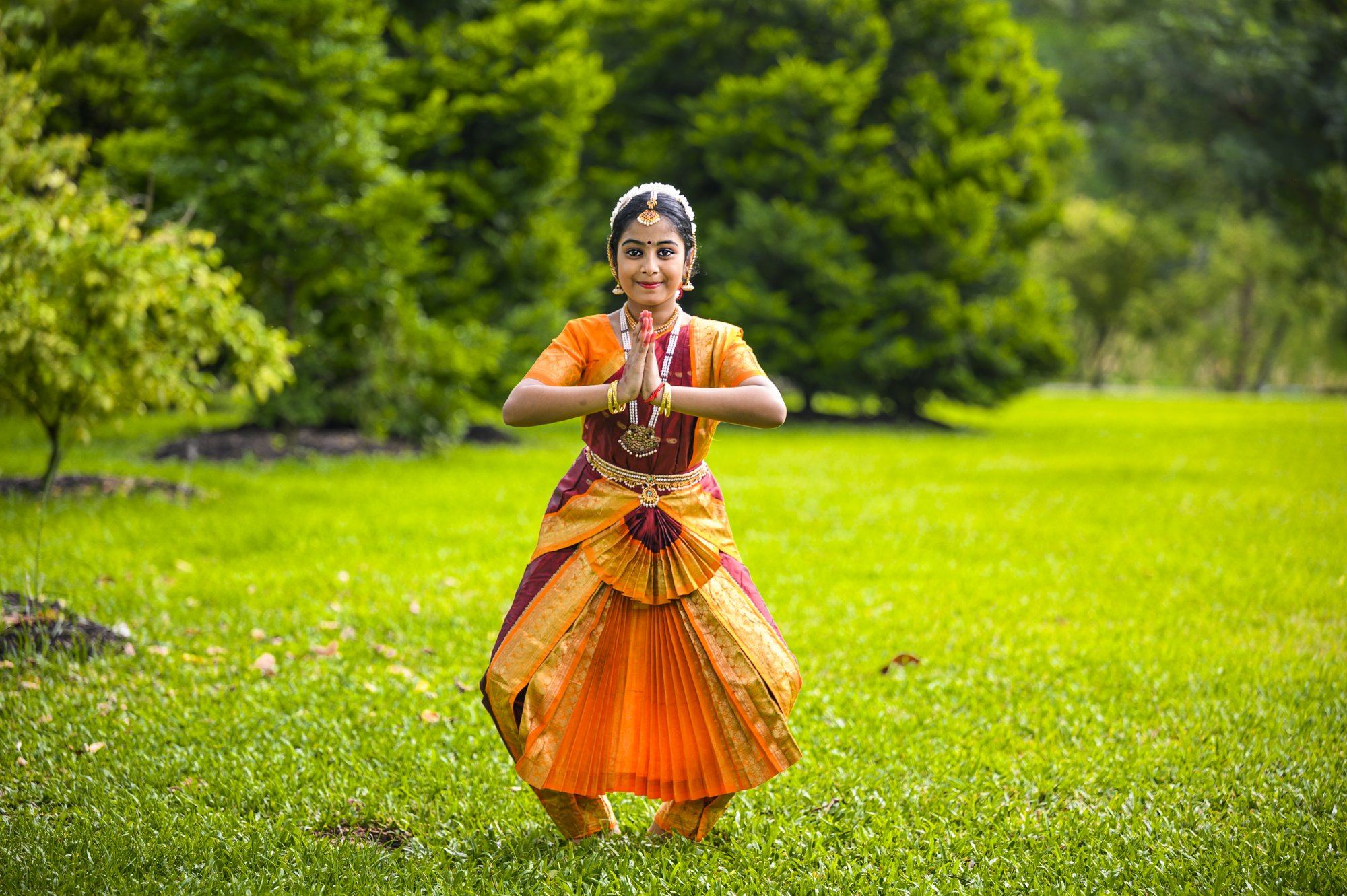 A young student offering namaskaram with folded hands before dancing