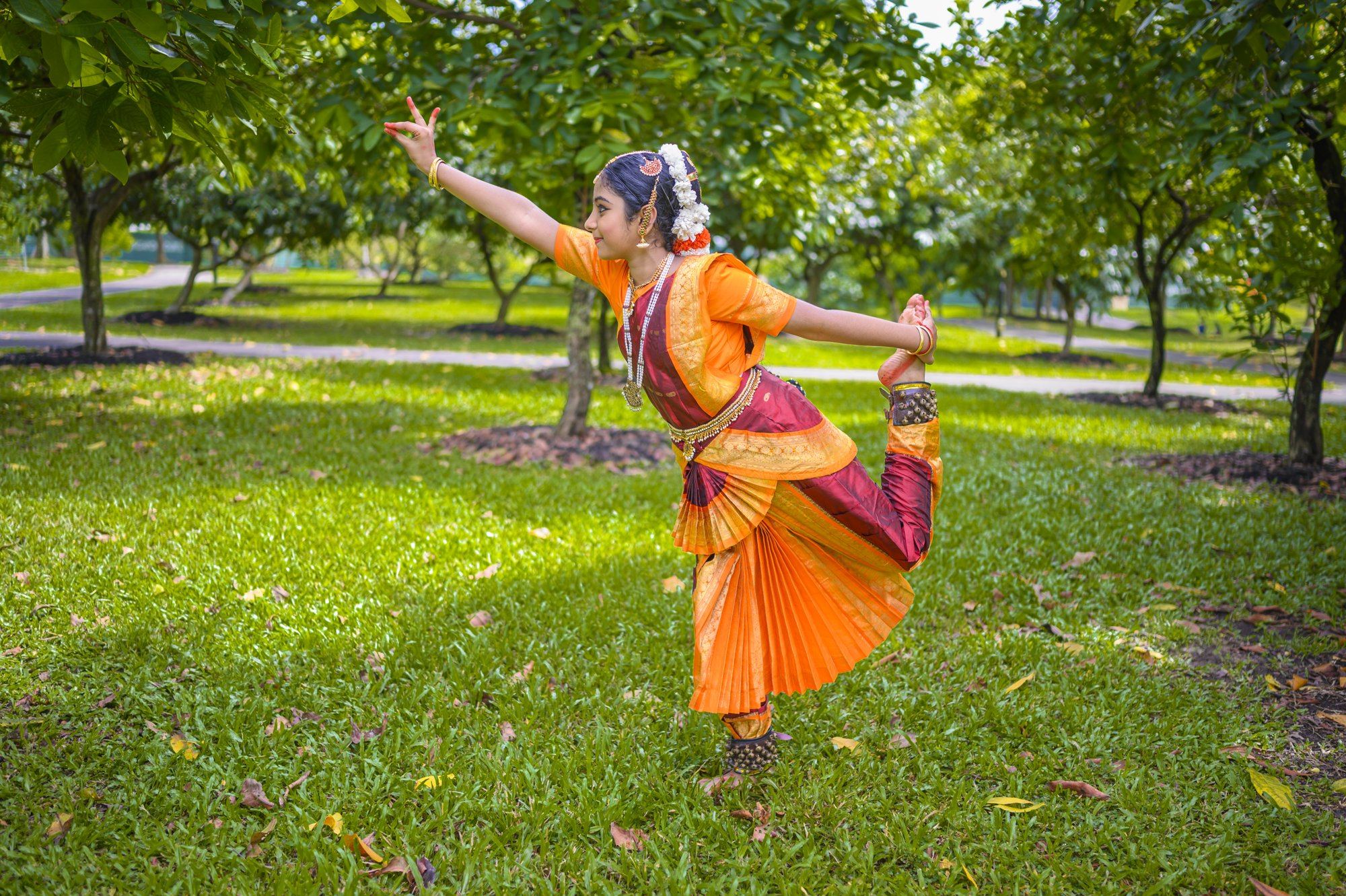 A dancer in an orange costume in a dynamic pose