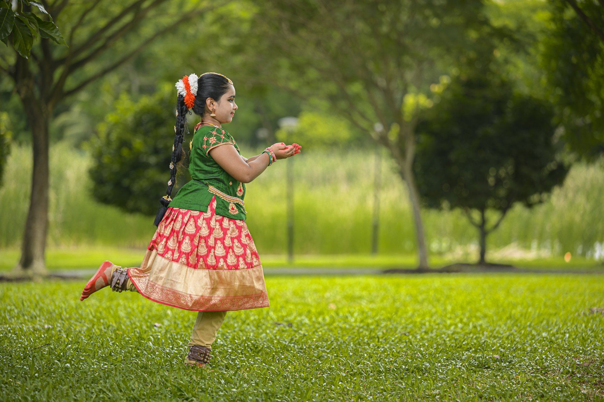 A young student leaping mid-dance on the lawn