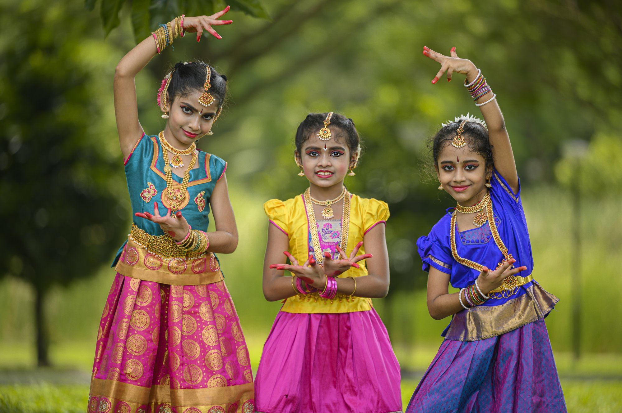 Three students performing a Bharatanatyam pose together