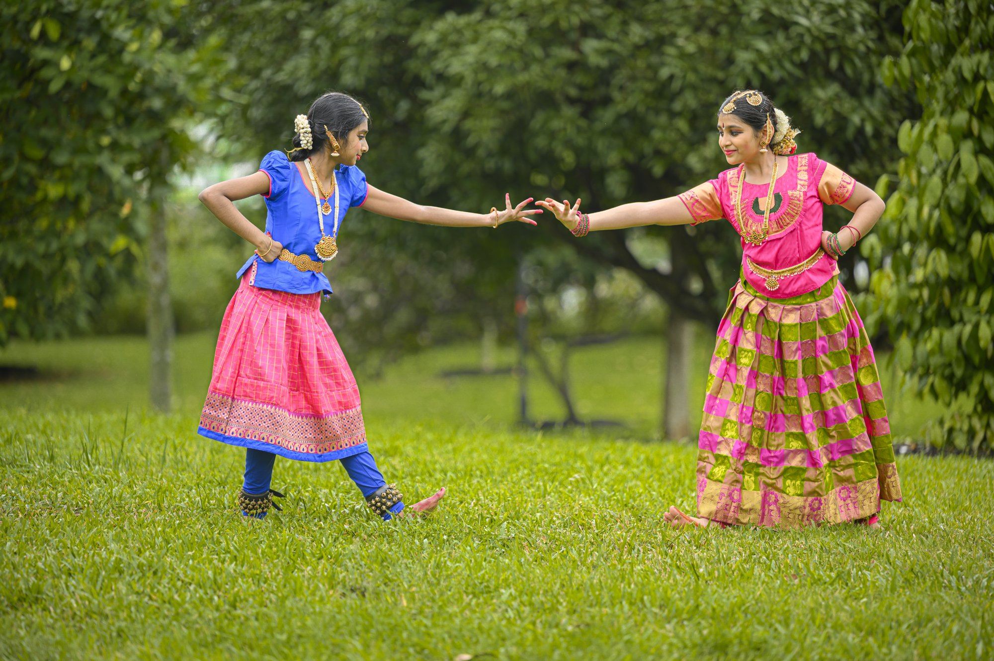 Two students reaching towards each other in a duet