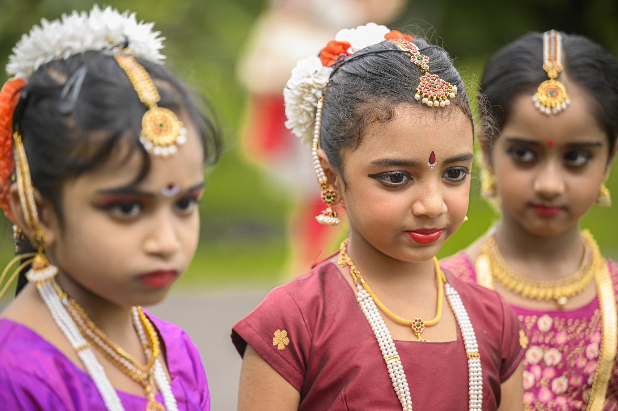 Two young students in costume and jewellery, looking on curiously