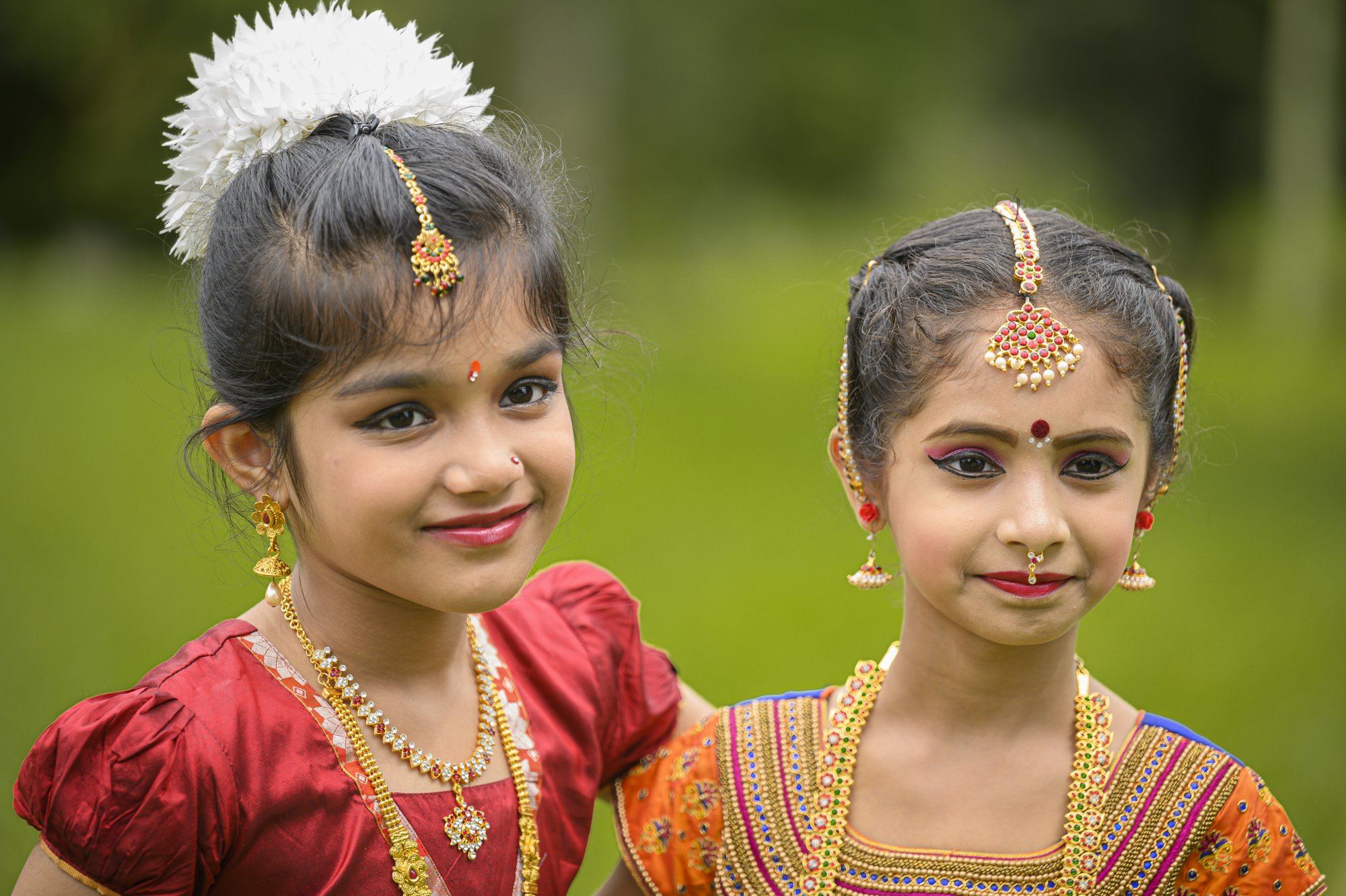 Two smiling young students in Bharatanatyam costume and jewellery