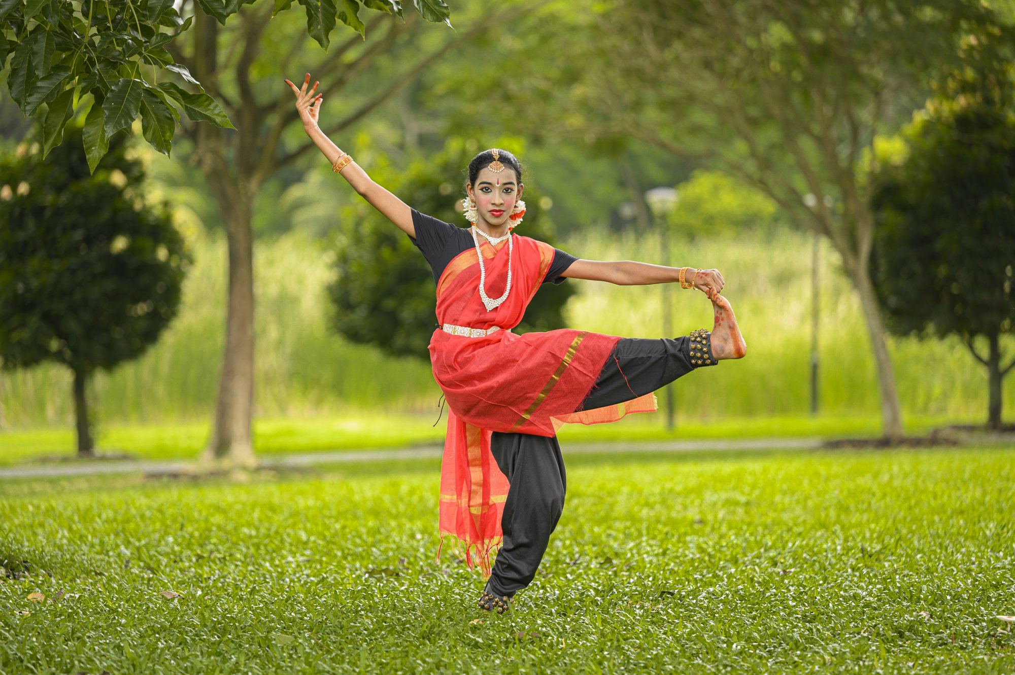 A senior student holding an advanced Bharatanatyam balance pose