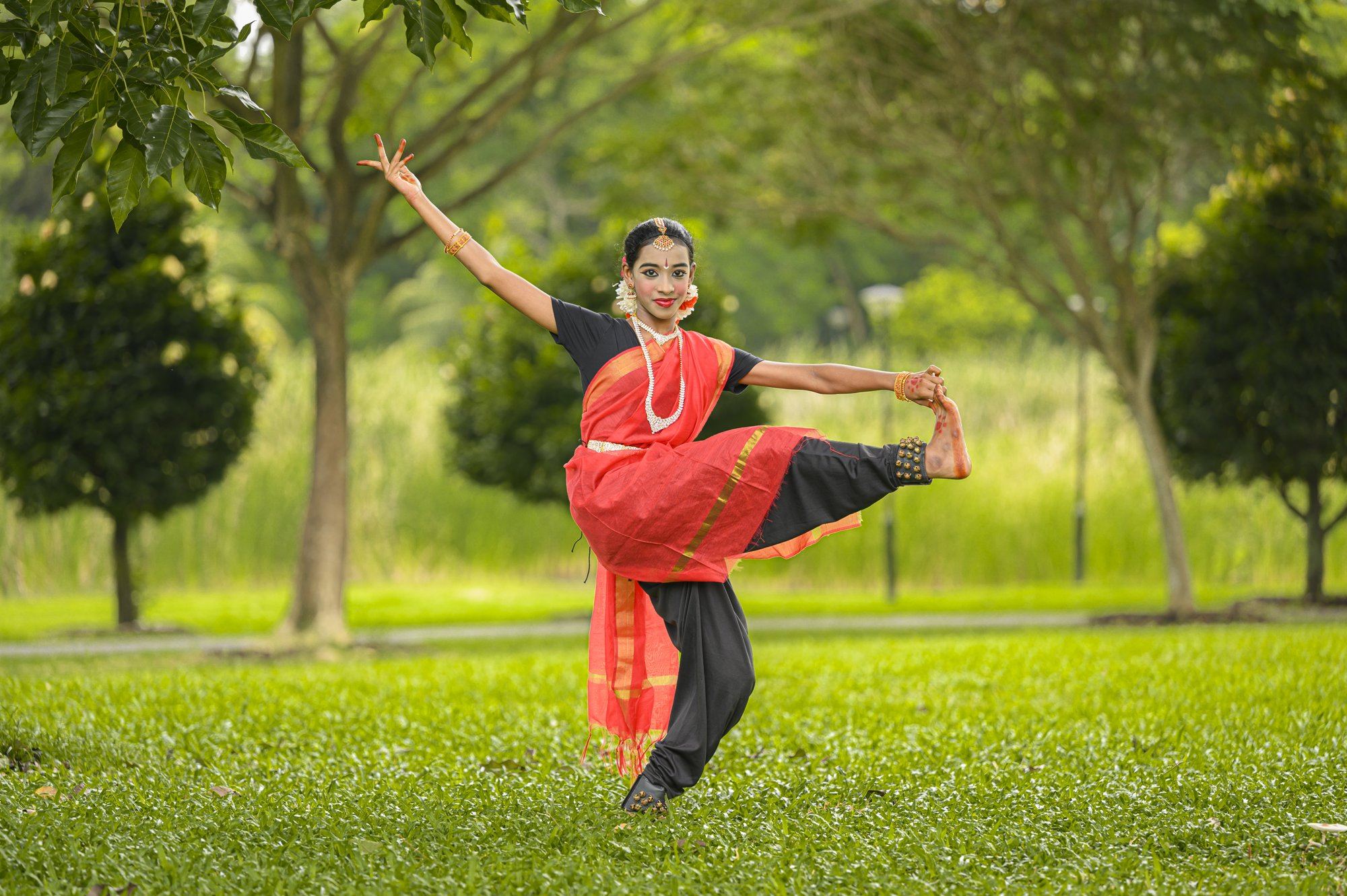 A senior student in a graceful Bharatanatyam pose