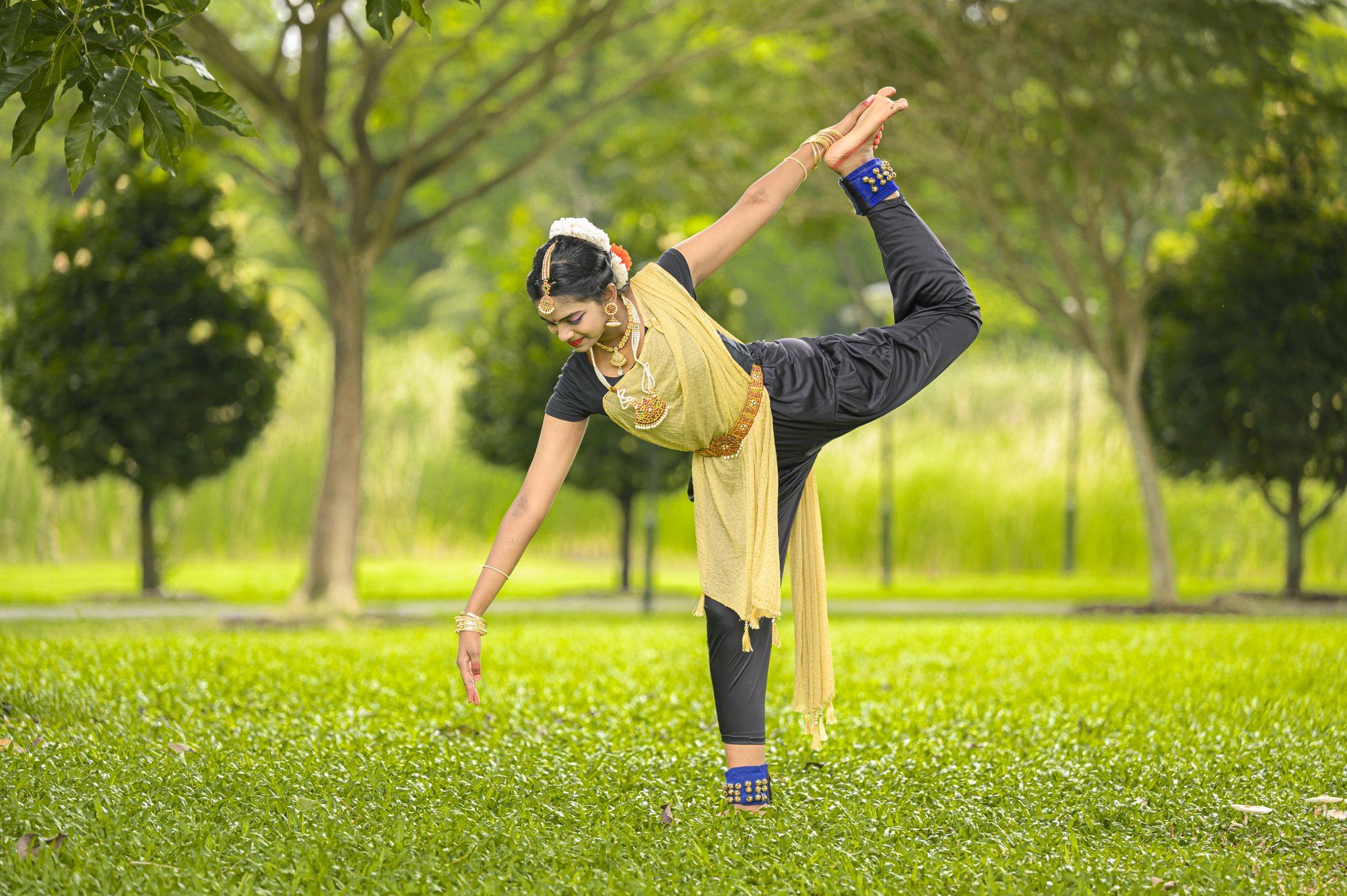 A senior student holding a high leg-extension pose