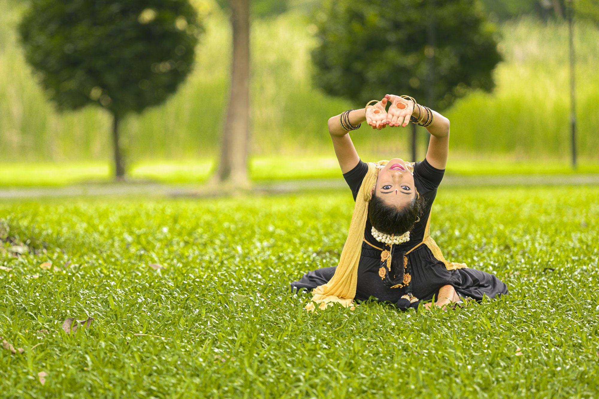 A dancer in a graceful backbend pose outdoors